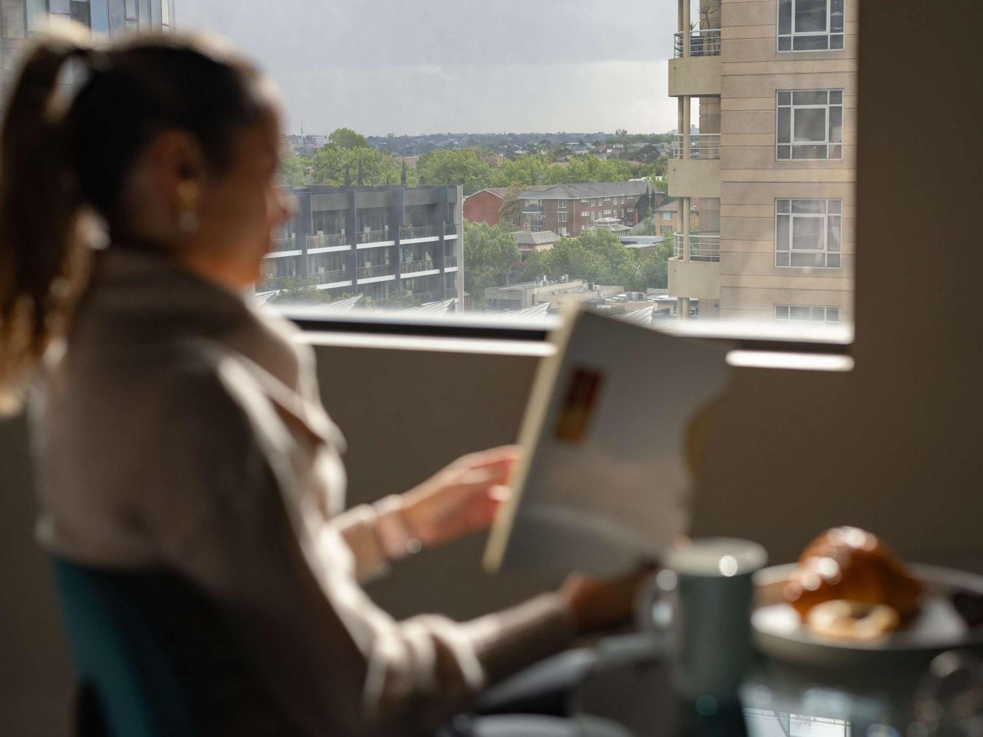 The Olsen Melbourne Art Series Bagian luar foto A woman using a tablet